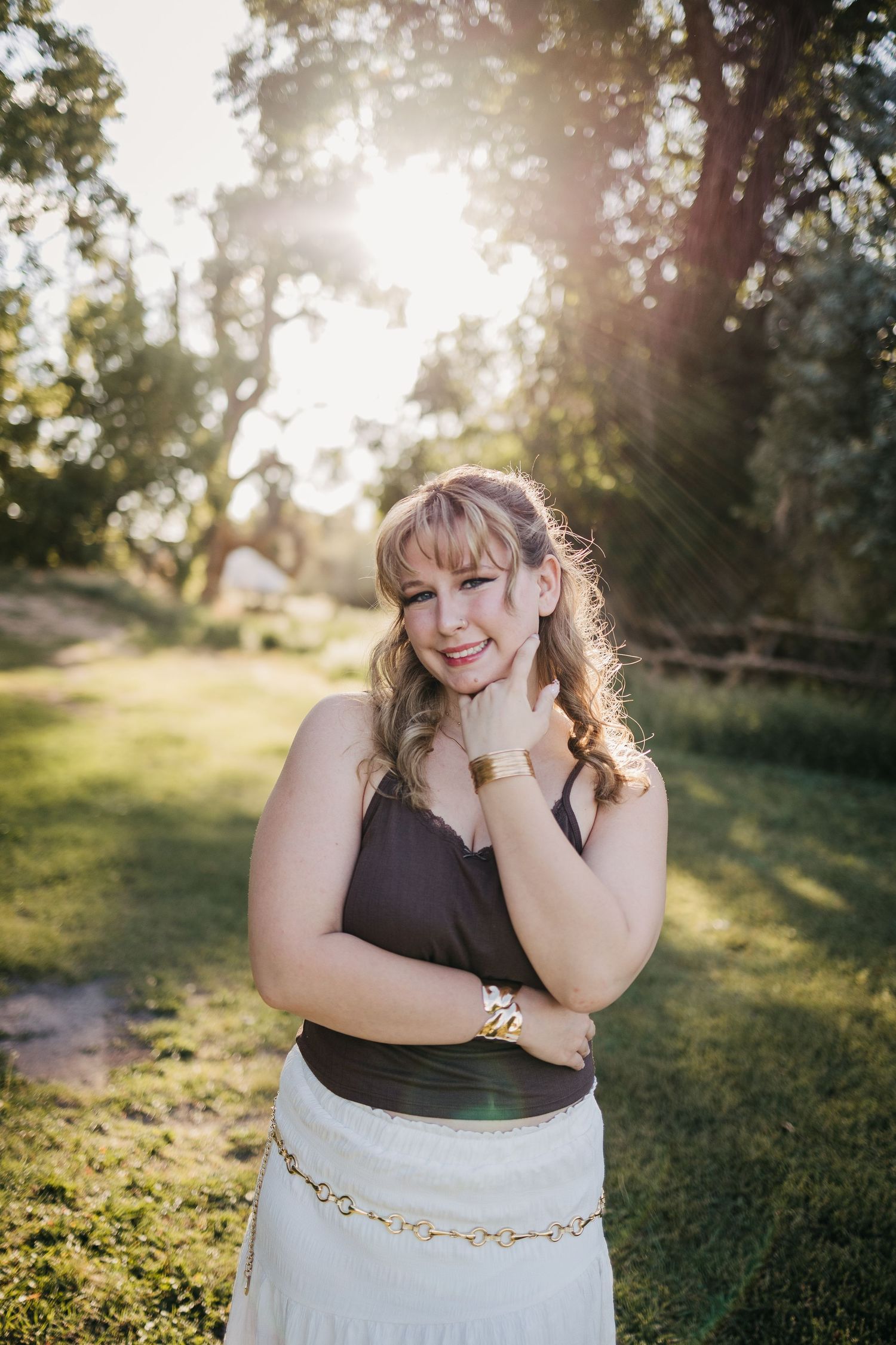 A beautiful high school senior in a sunflower field during golden hour
