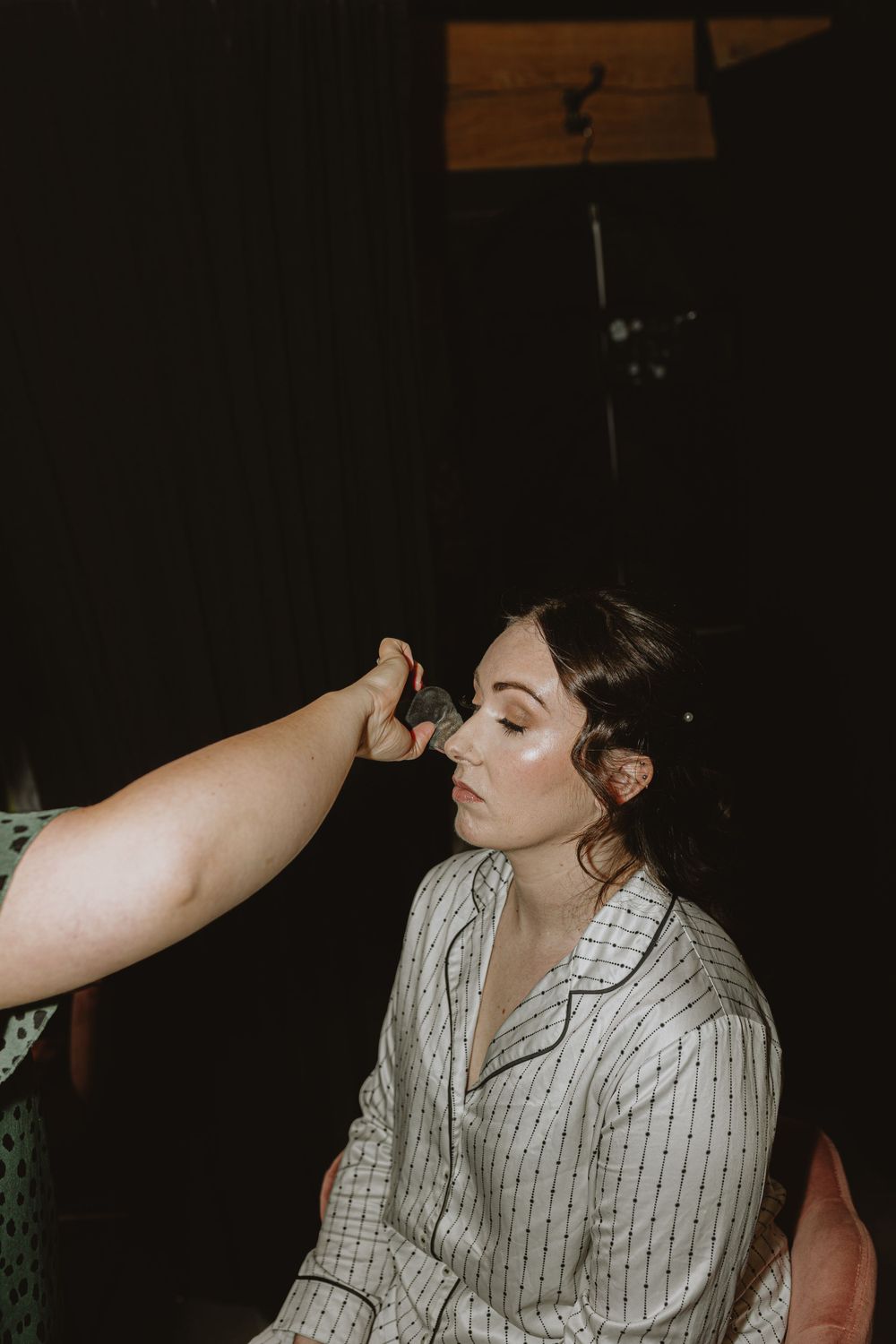 Getting ready moments captured in dramatic lighting.