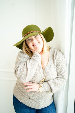 Cozy winter fashion shoot with olive green hat and cream sweater.