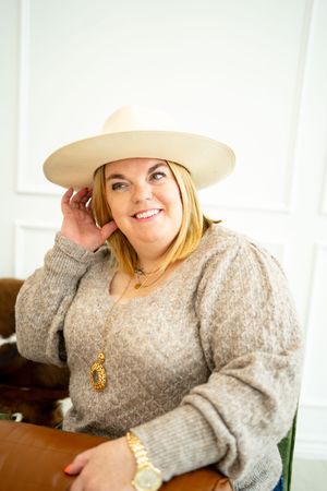 Casual portrait series featuring beige hat and textured sweater in bright setting.