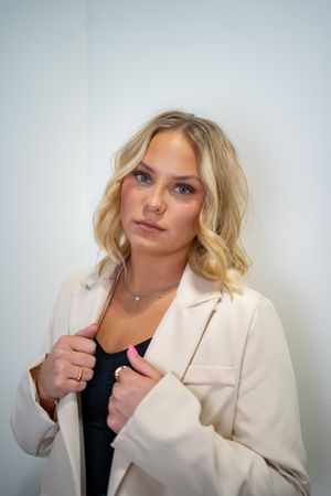 Professional headshots of a woman in a cream blazer against a light gray background.