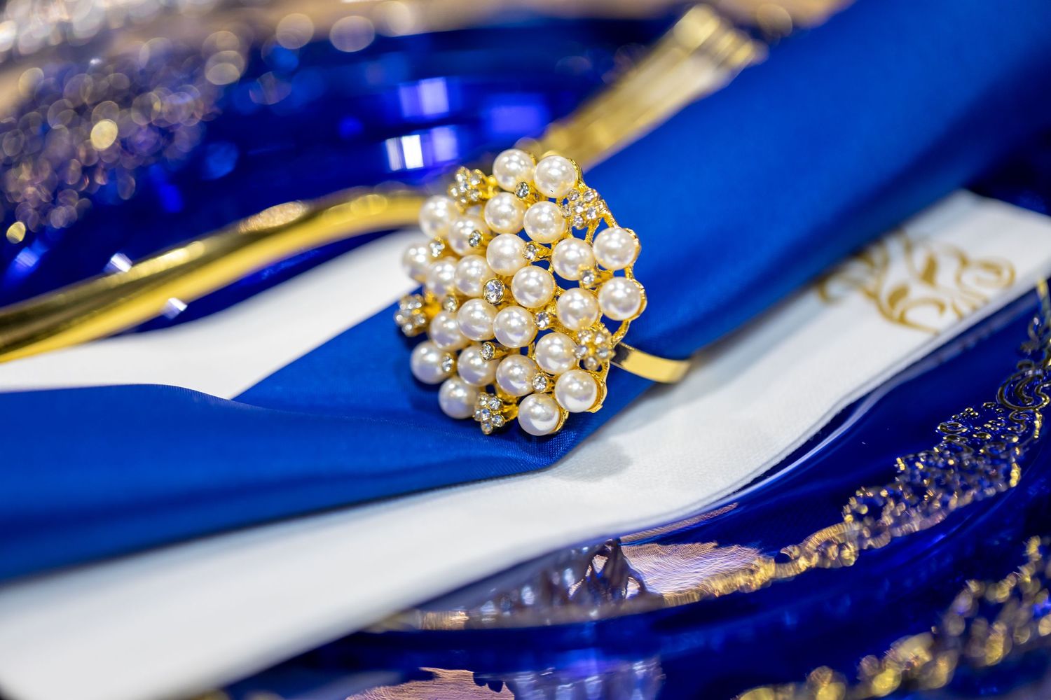 Close-up of a pearl cluster ring on blue and white fabric.