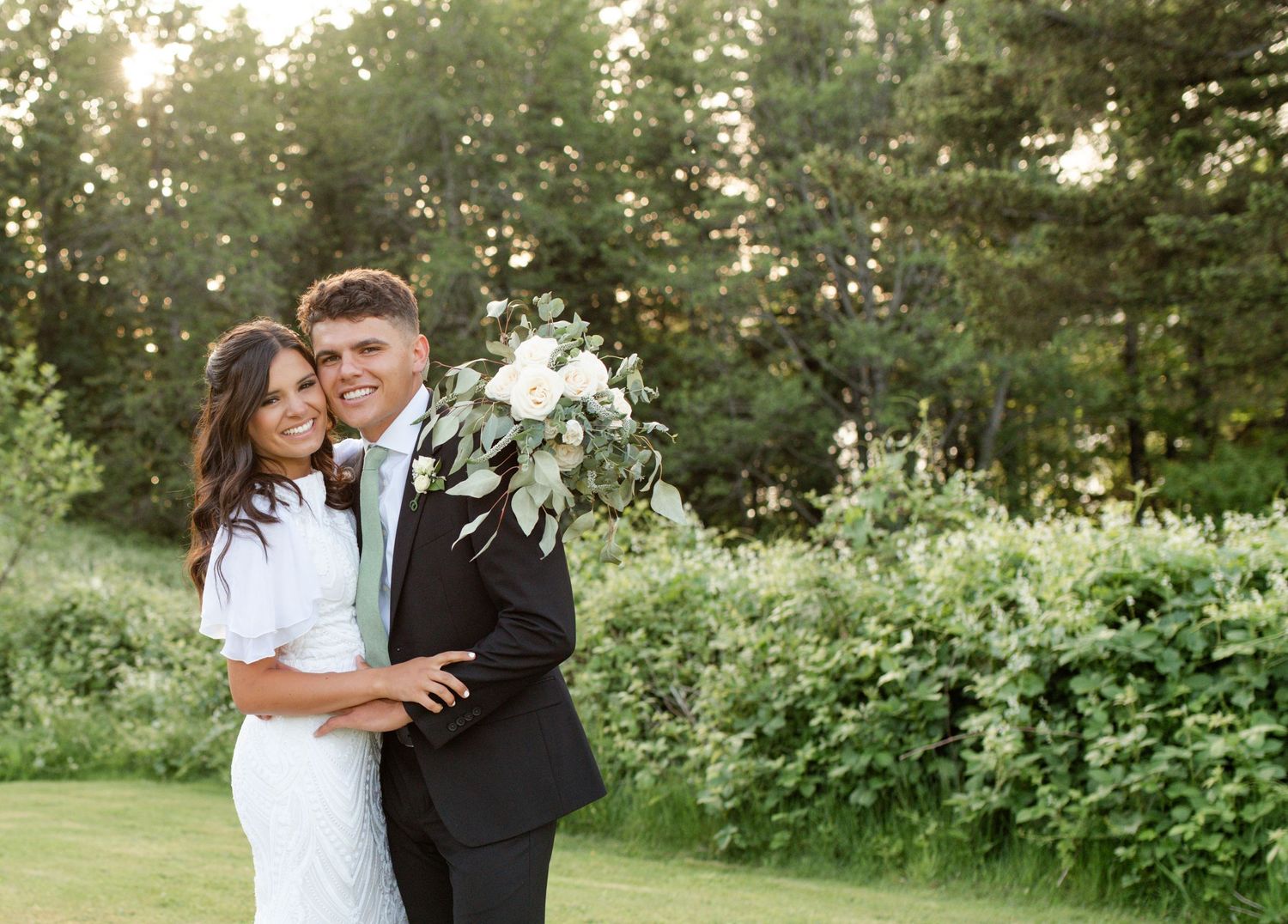 Bride and groom embracing outdoors on their wedding day captured by O'Fallon Missouri wedding photographer.