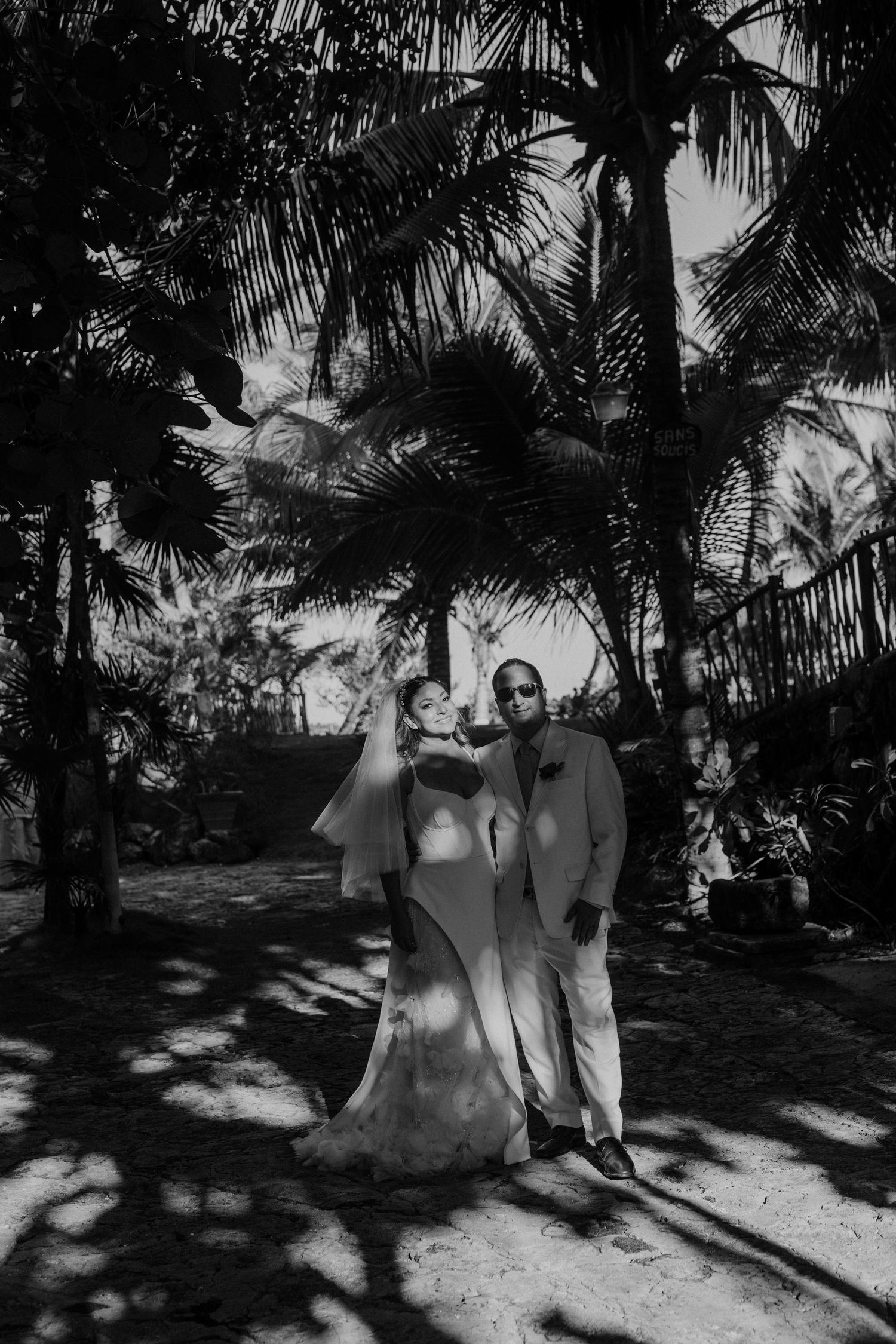 Couple embracing by a pool with ocean views under a blue sky at a beachfront wedding venue Villas La Joya.