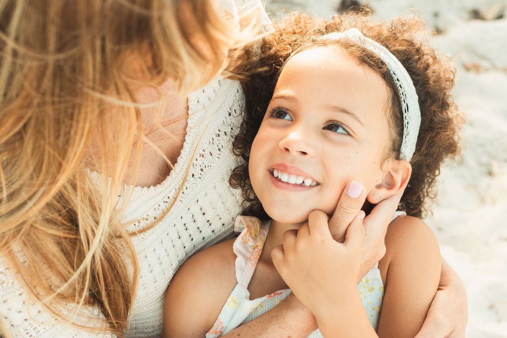 tender moment between mother and daughter, mother cradling her daughter's face