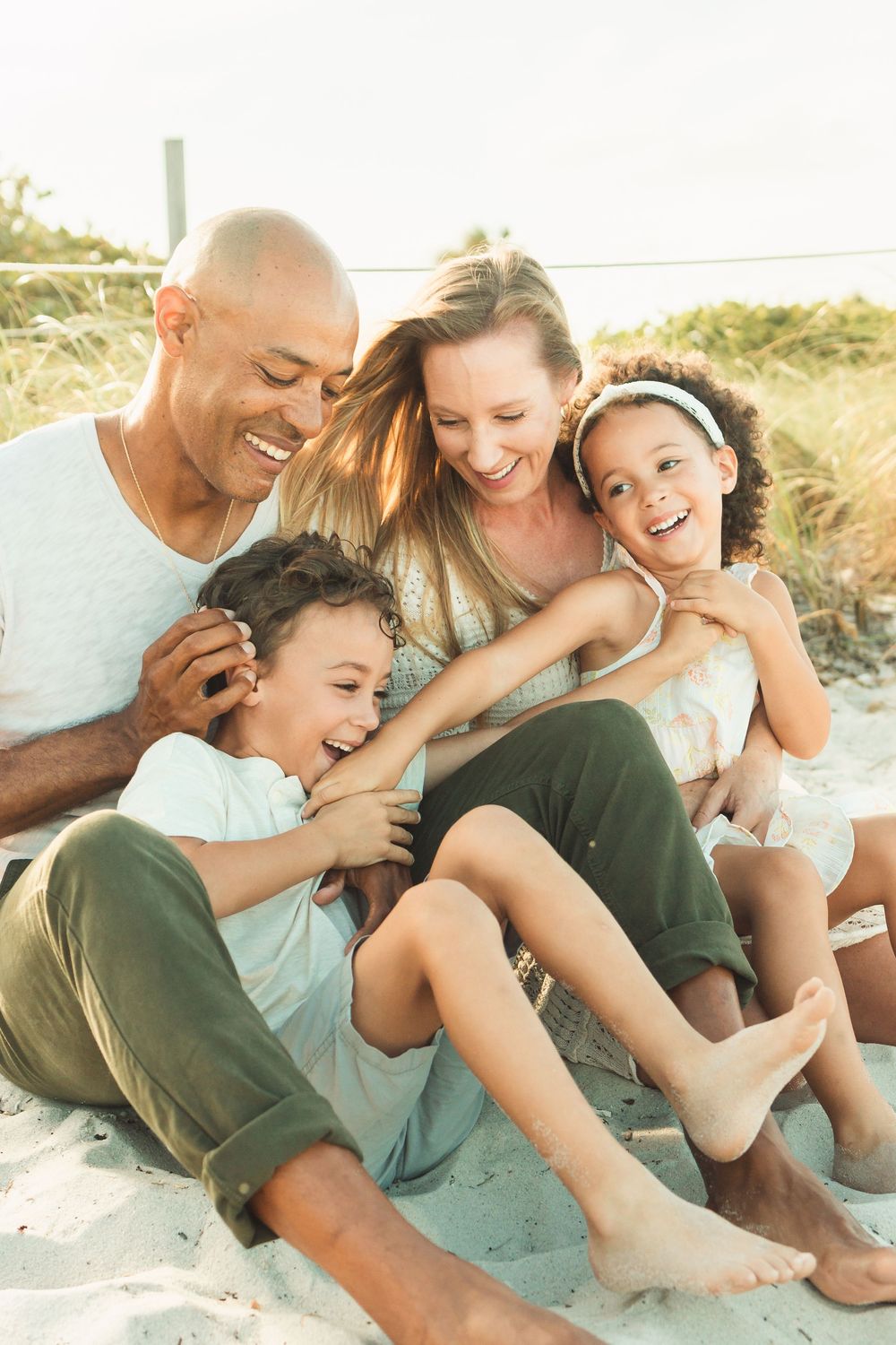 family snuggles at the beach, family sitting down
