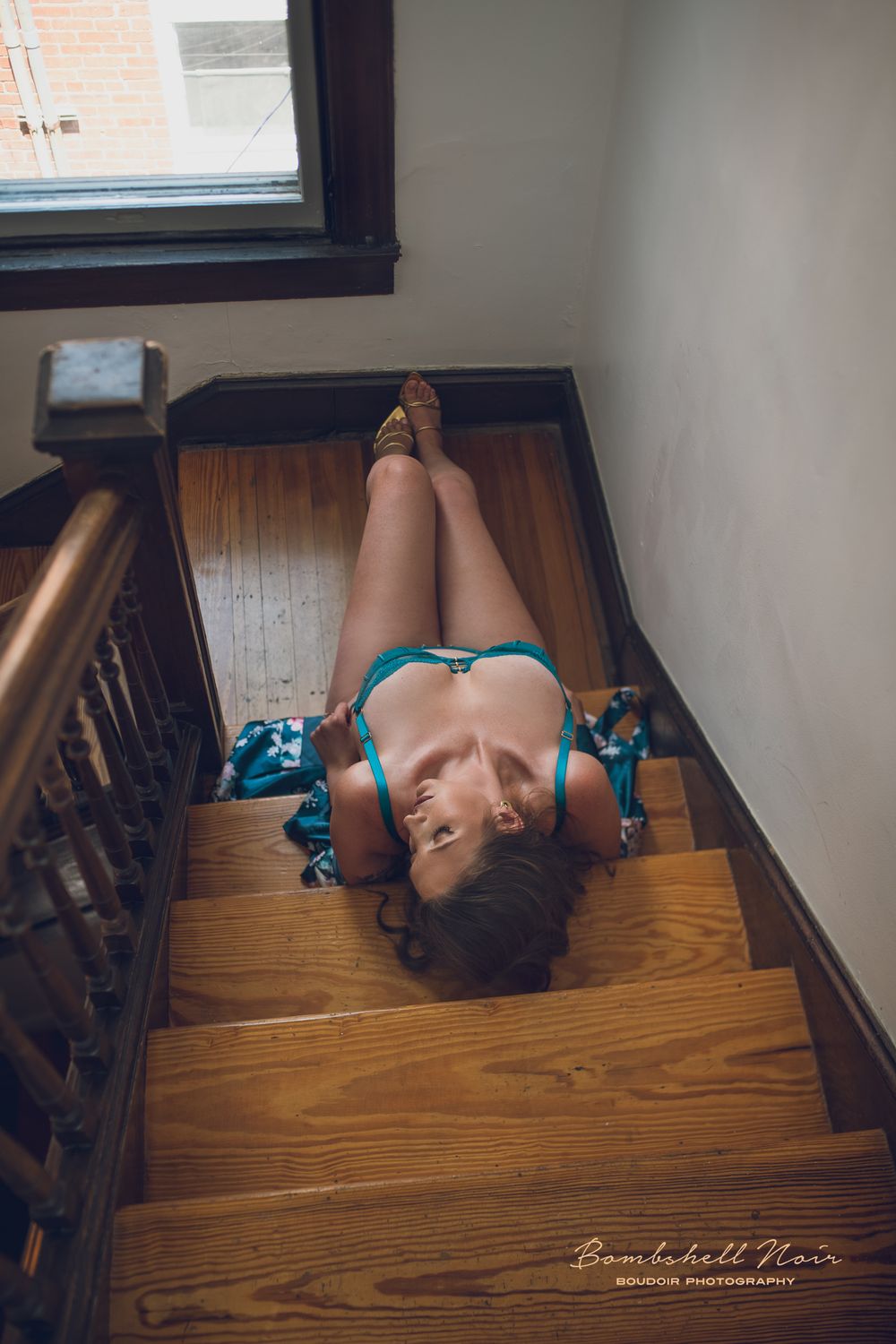 A series of four photos showing someone lying on hardwood stairs in a turquoise dress in different artistic poses.