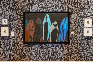 Andy Warhol-style framed shoe print artwork displayed on a black and white patterned wallpaper with smaller framed prints.