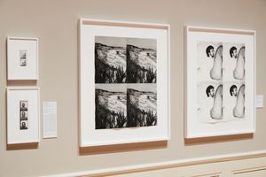 Gallery wall displaying framed black-and-white artworks including a four-panel photo grid and figure drawings in a museum setting.