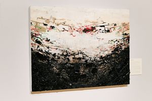 Abstract painting with black textured base and white upper section with colorful paint strokes displayed on gallery wall.