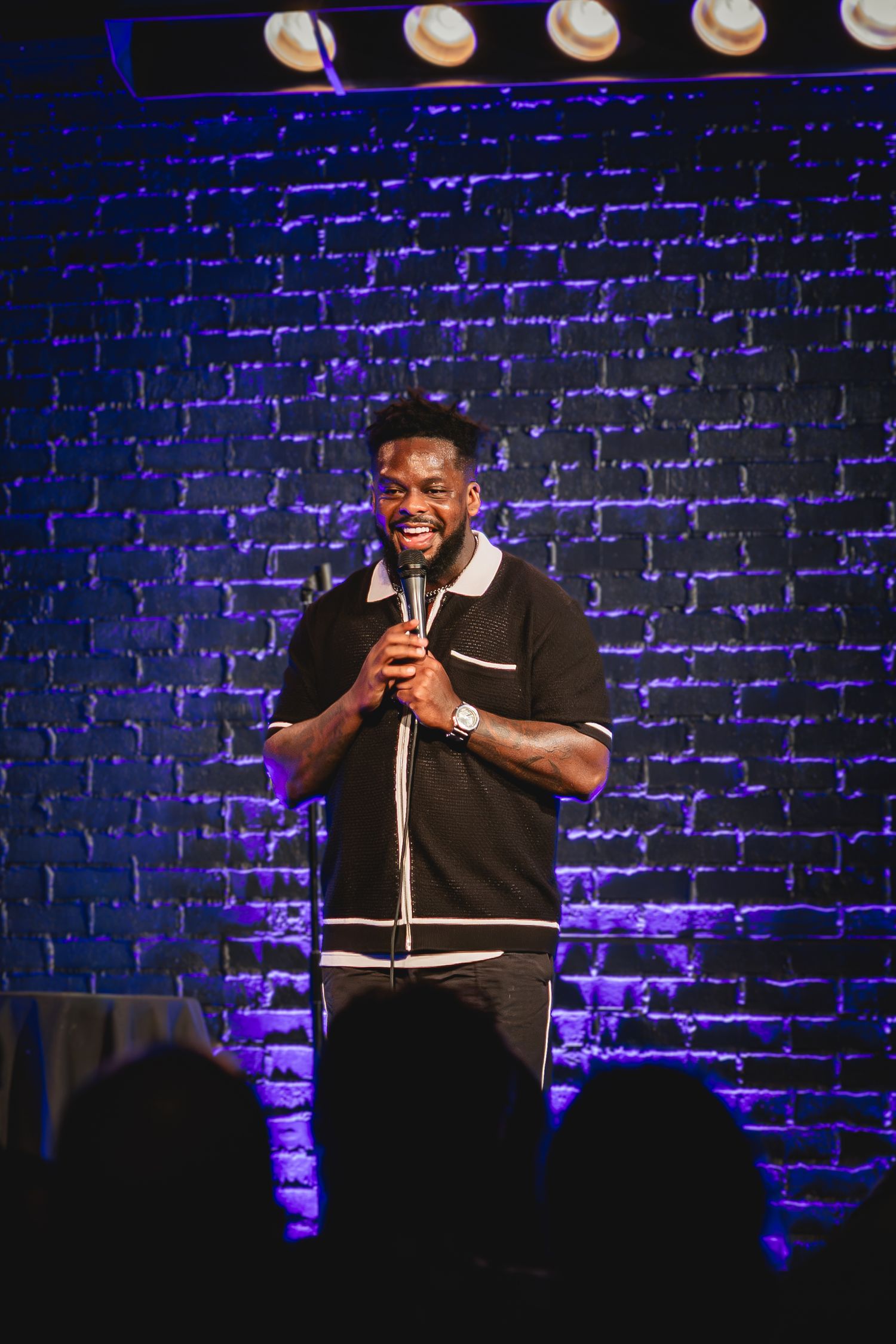 Dedrick Flynn the comedian performing stand-up comedy on stage holding a microphone at Side Splitters Comedy Club Tampa. Videography. Photo