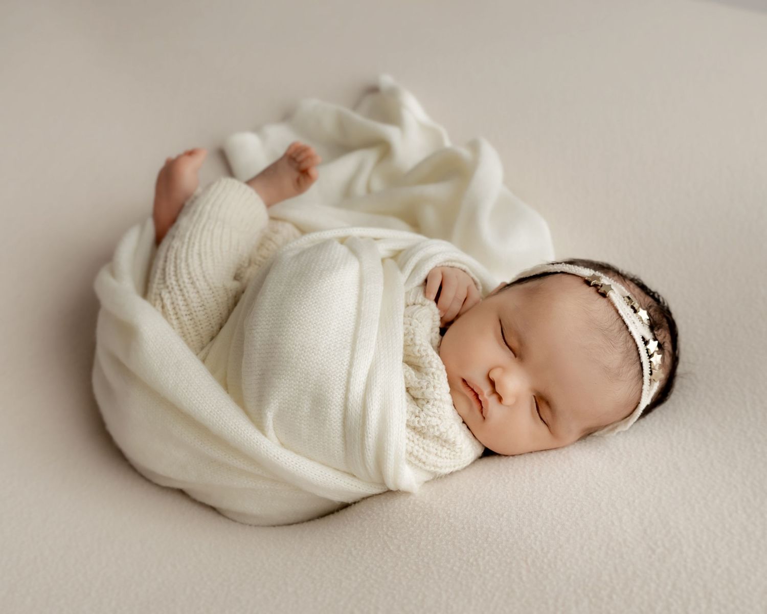 Newborn baby wrapped comfortably during portrait session