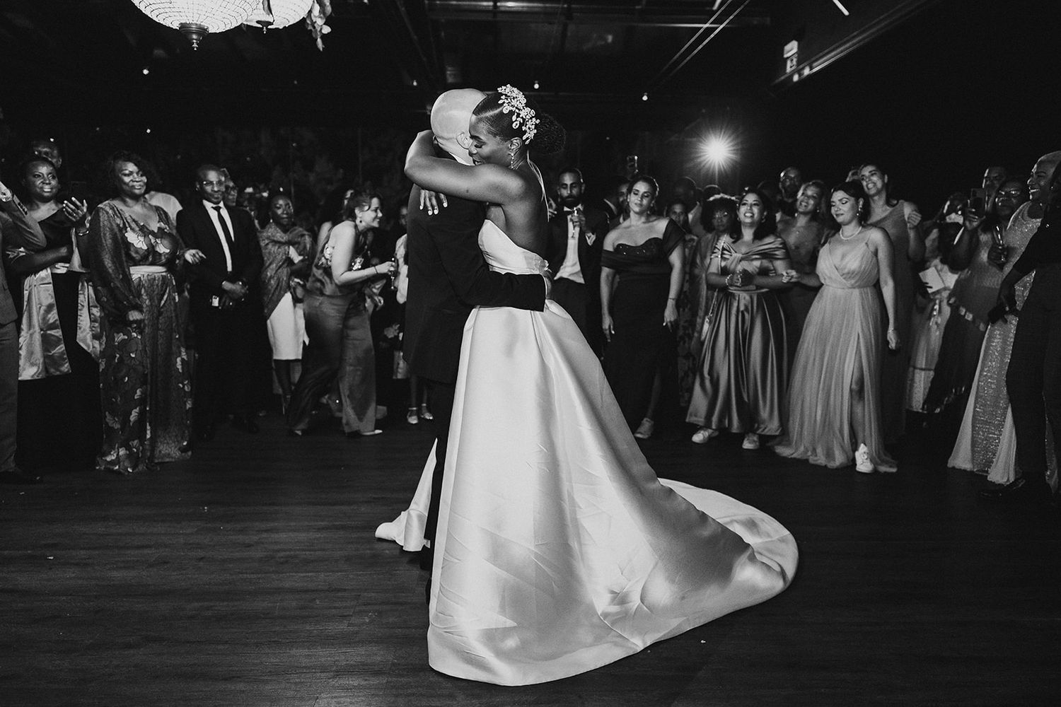 A romantic first dance moment at a wedding reception captured in black and white.