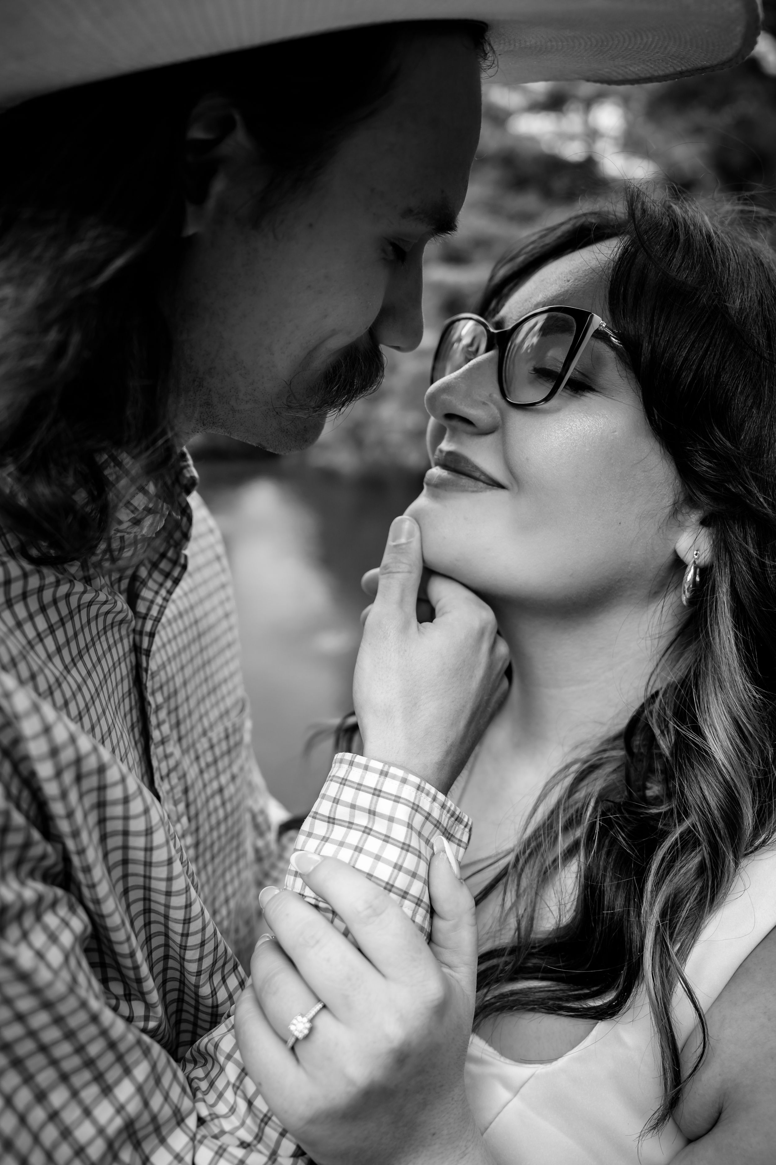 Intimate black and white portrait of a couple about to kiss, man gently lifting womans chin.
