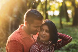 Loving couple sharing a tender moment together in a sunlit forest.