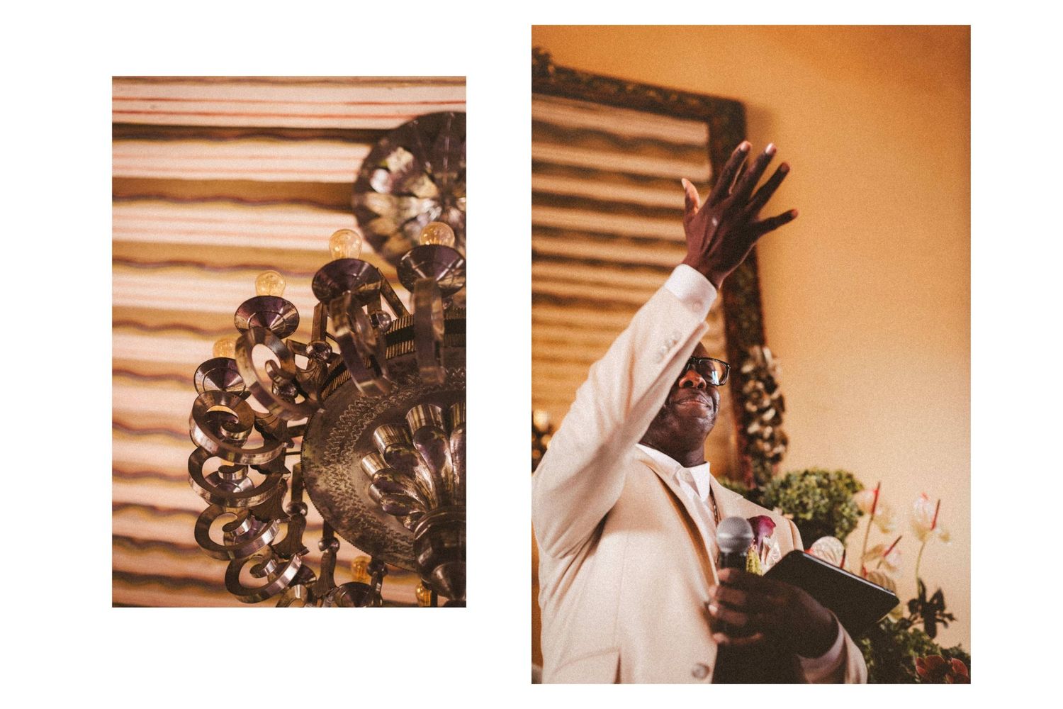 Man in white suit raising hand near wall art, beside ornate gold decorative sculpture at elegant event.