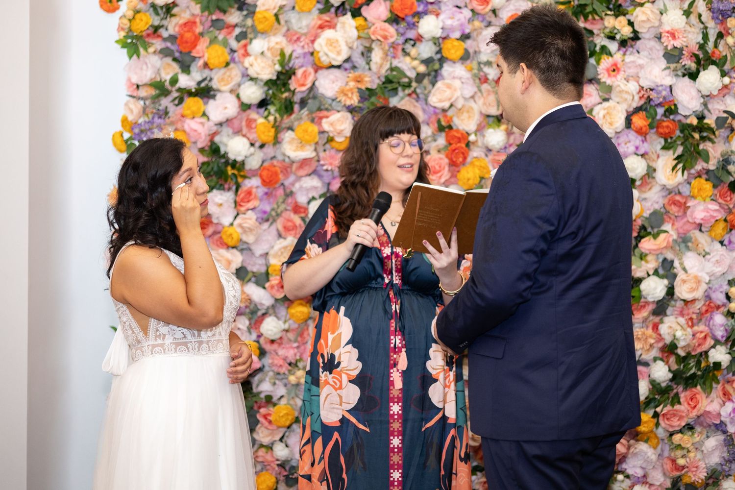 Colorful floral wall Couple exchanging vows during their intimate Cincinnati elopement at Nine Giant