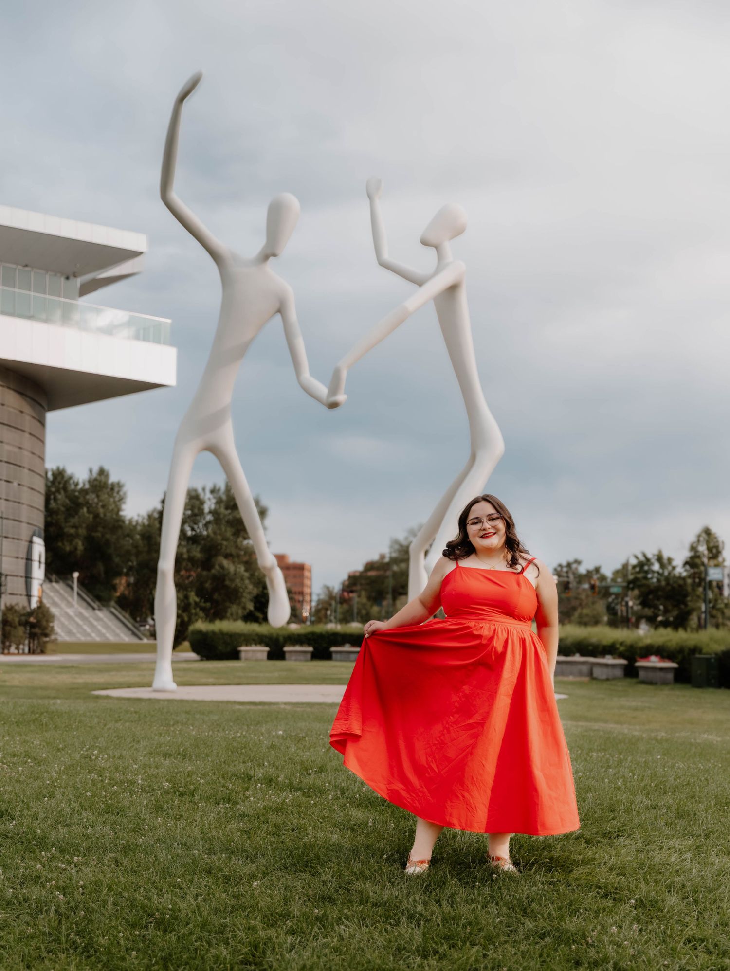 Girl stands swaying her dress and poses for senior photos, cinematic, urban, and portrait photos in Denver, Colorado outside and in nature