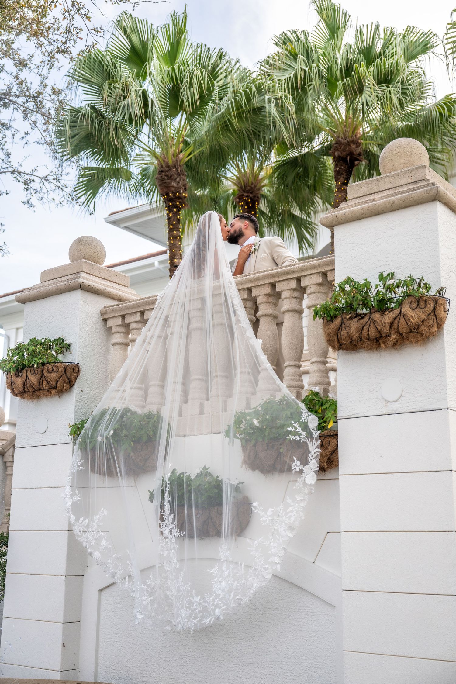 A romantic wedding kiss captured outdoors with soft dreamy lighting.
