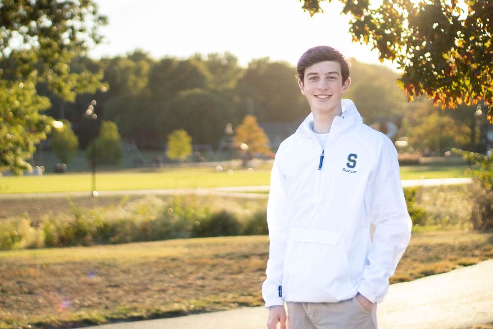 Senior photo in Kansas City at golden hour with the sunset in the background.