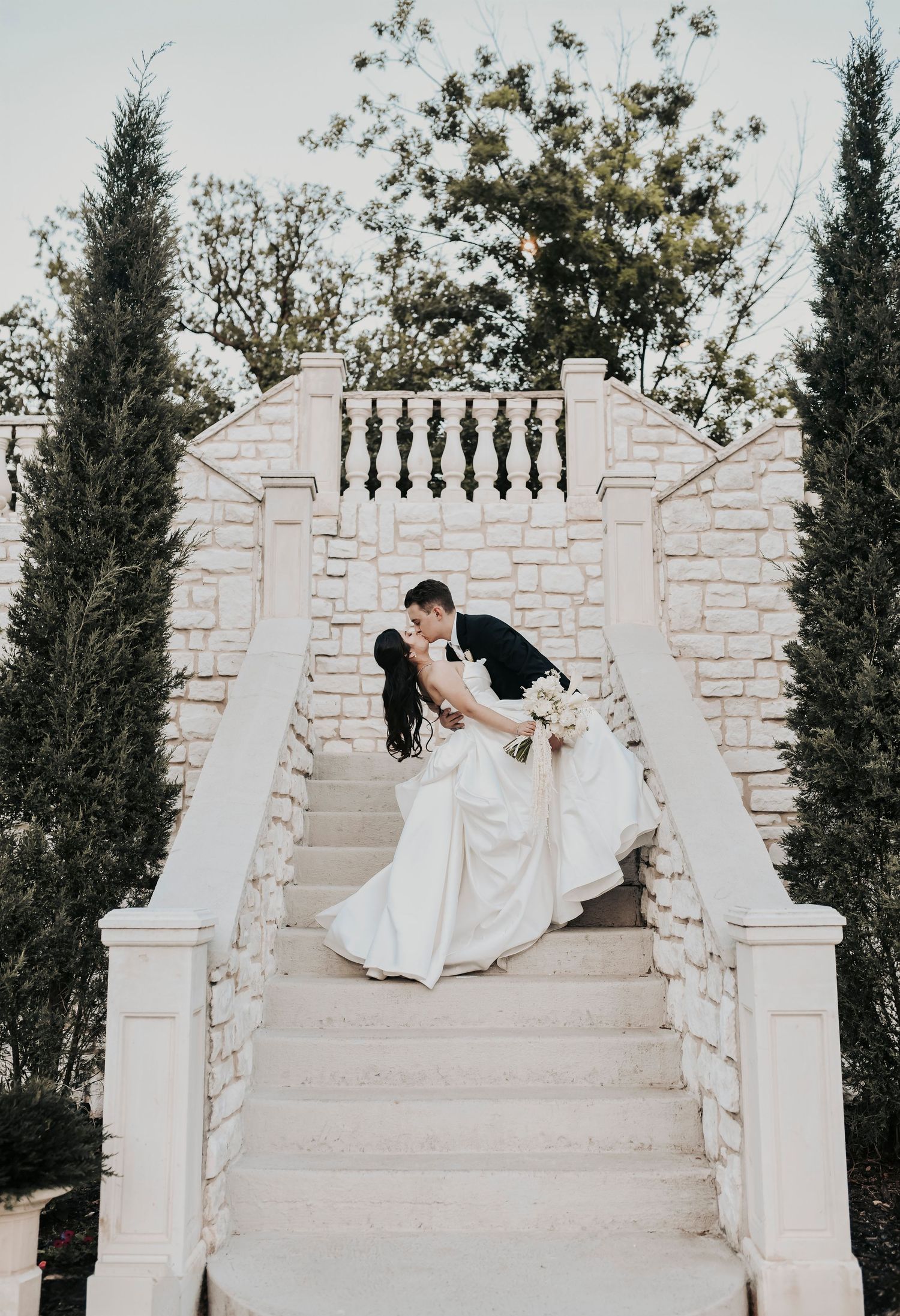 Newlyweds sharing a kiss beneath warm evening light