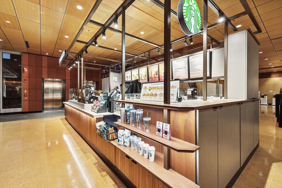 Starbucks coffee shop counter with wood paneling, menu boards, and retail merchandise displays.