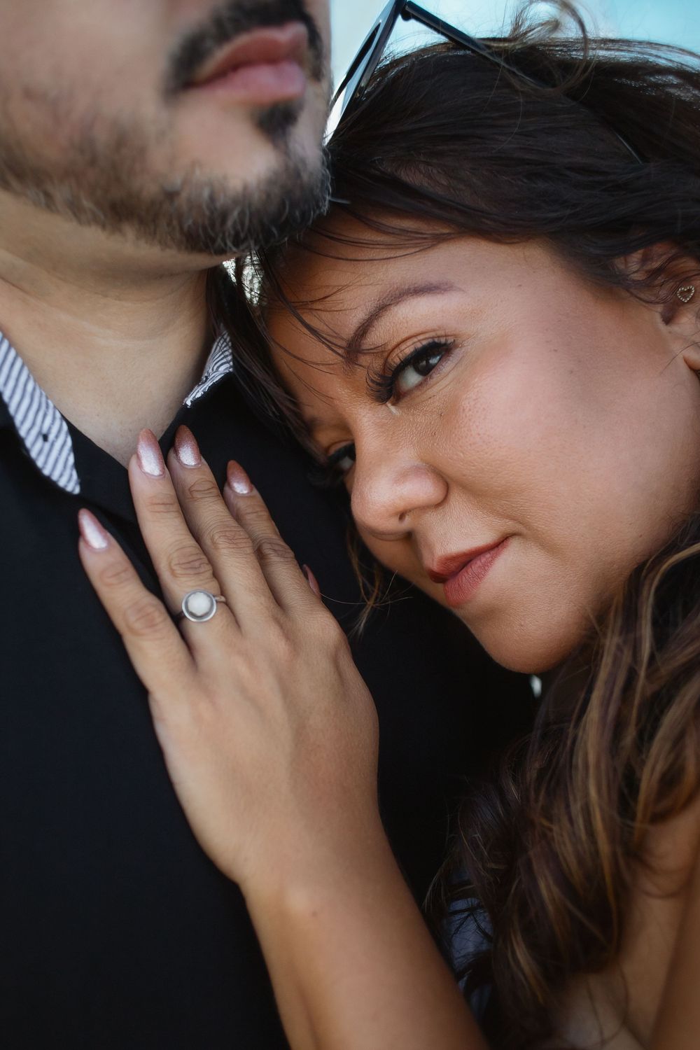 Couple embracing at Pompano Beach Pier during engagement couples session.