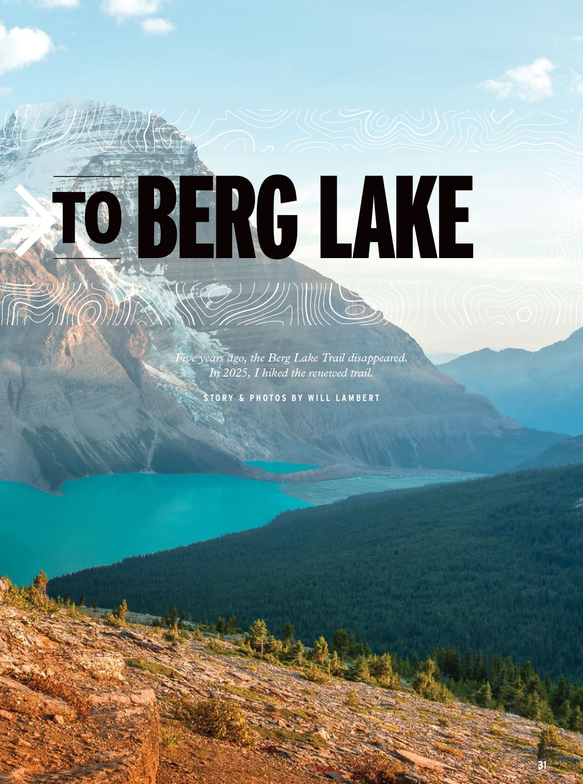 A scenic mountain landscape with turquoise lake waters and evergreen forests stretching beneath snow-capped peaks at dusk.