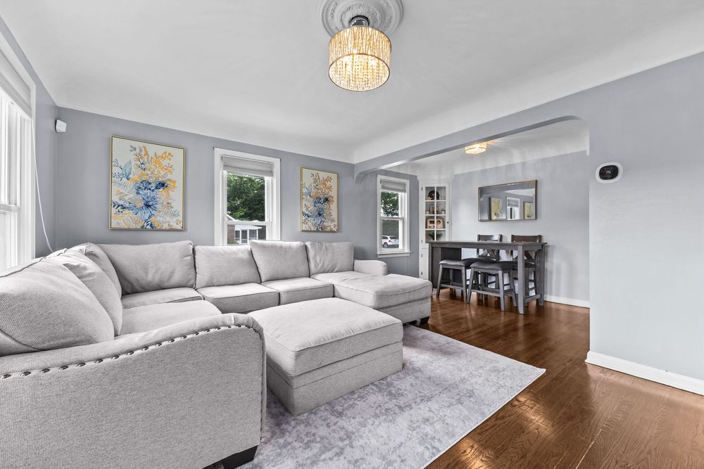 Living room with hardwood floors and chandelier in Dearborn Michigan bungalow on Lawrence Avenue