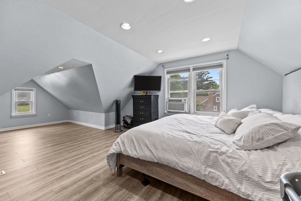 Upper bedroom with vaulted ceiling and hardwood floors in Dearborn Michigan bungalow
