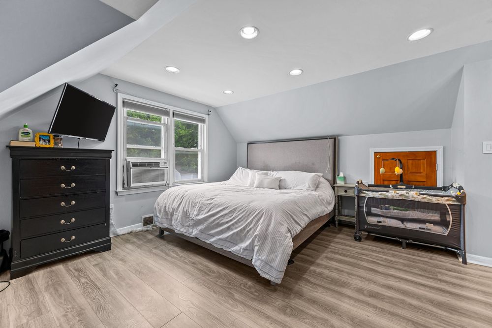 Upper bedroom with vaulted ceiling and hardwood floors in Dearborn Michigan bungalow
