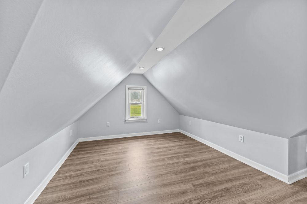 Upper bedroom with vaulted ceiling and hardwood floors in Dearborn Michigan bungalow