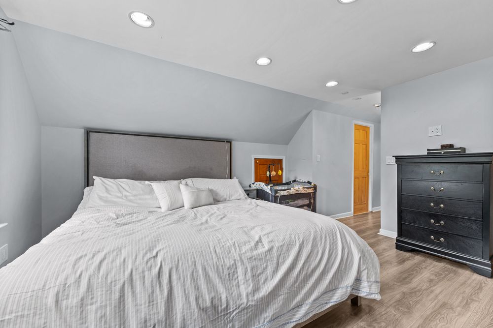 Upper bedroom with vaulted ceiling and hardwood floors in Dearborn Michigan bungalow