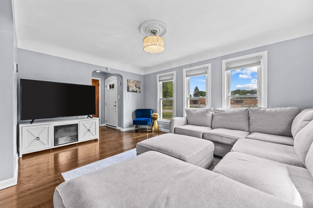 Living room with hardwood floors and chandelier in Dearborn Michigan bungalow on Lawrence Avenue