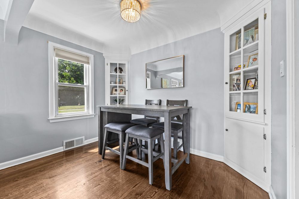 Living room with hardwood floors and chandelier in Dearborn Michigan bungalow on Lawrence Avenue