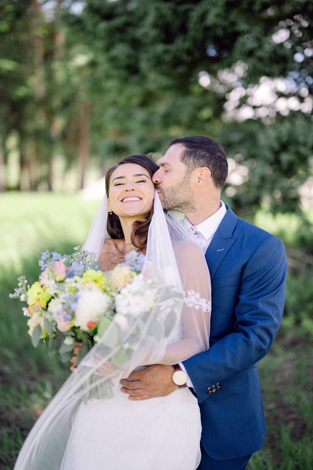 A tender moment captured between newlyweds in an outdoor garden setting.