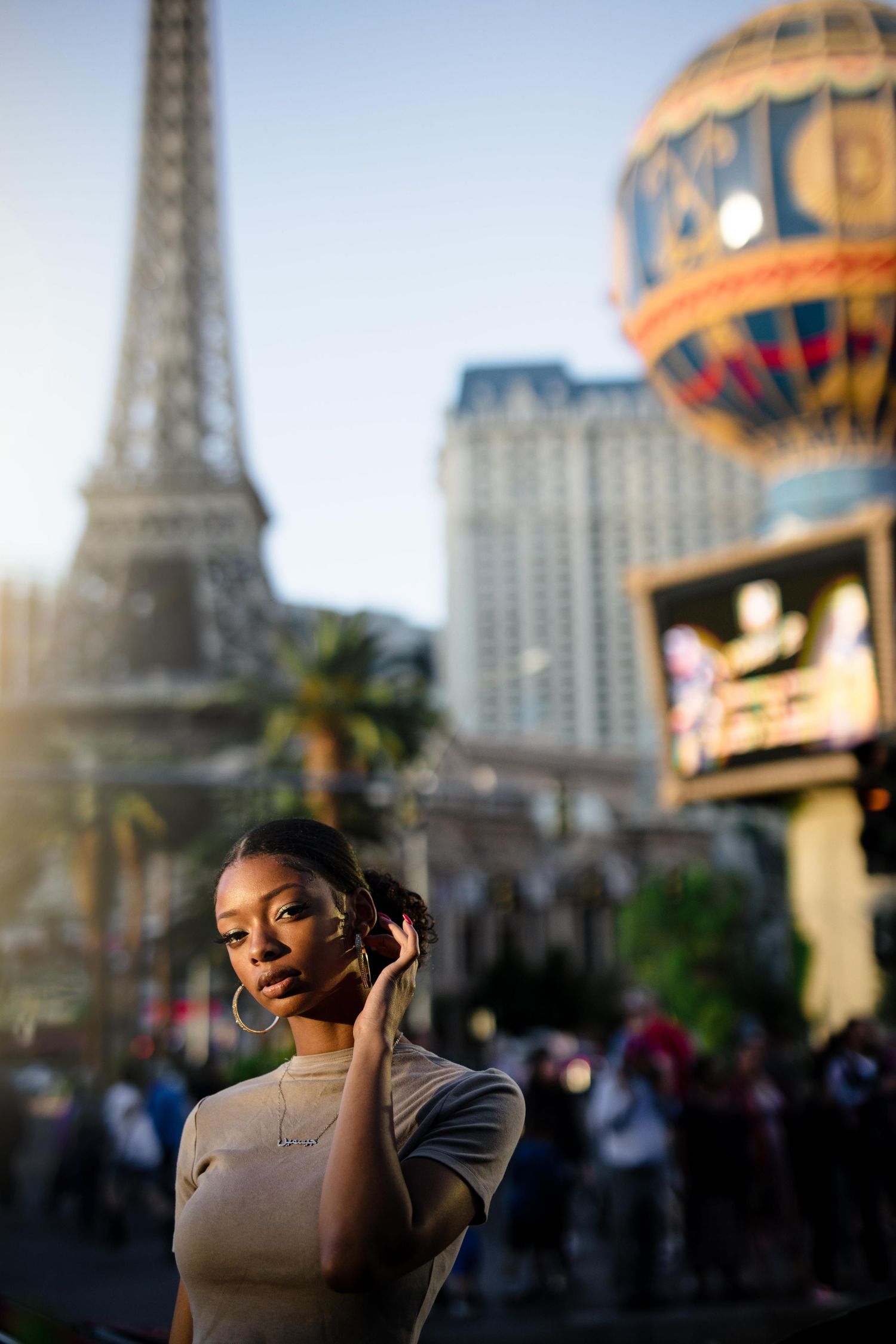 In front of the replica Eiffel Tower at Paris Las Vegas resort, evening sun creates a warm glow on the bustling Strip.