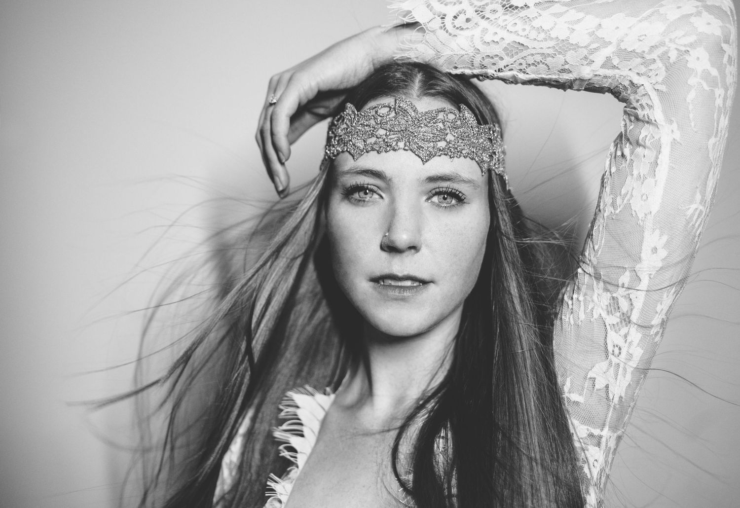 Black and white portrait of someone wearing a decorative headband and having long straight hair.