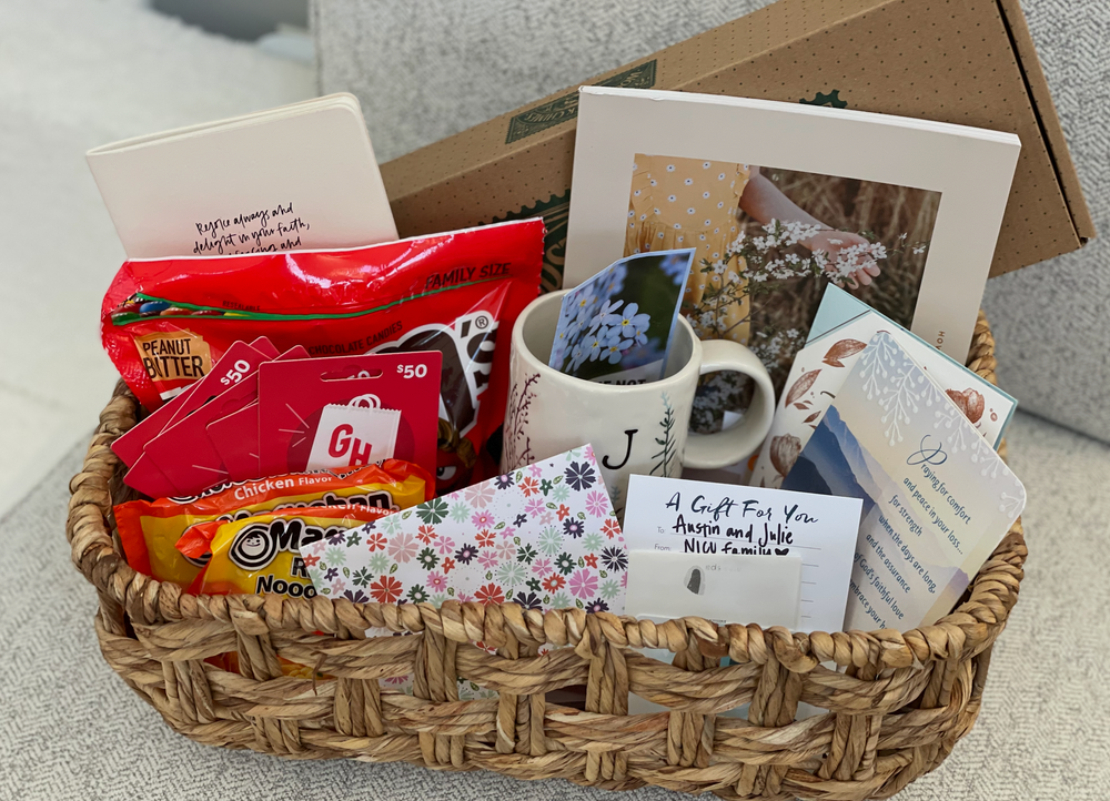 A woven basket filled with various snacks, drinks, and a coffee mug arranged as a gift basket.