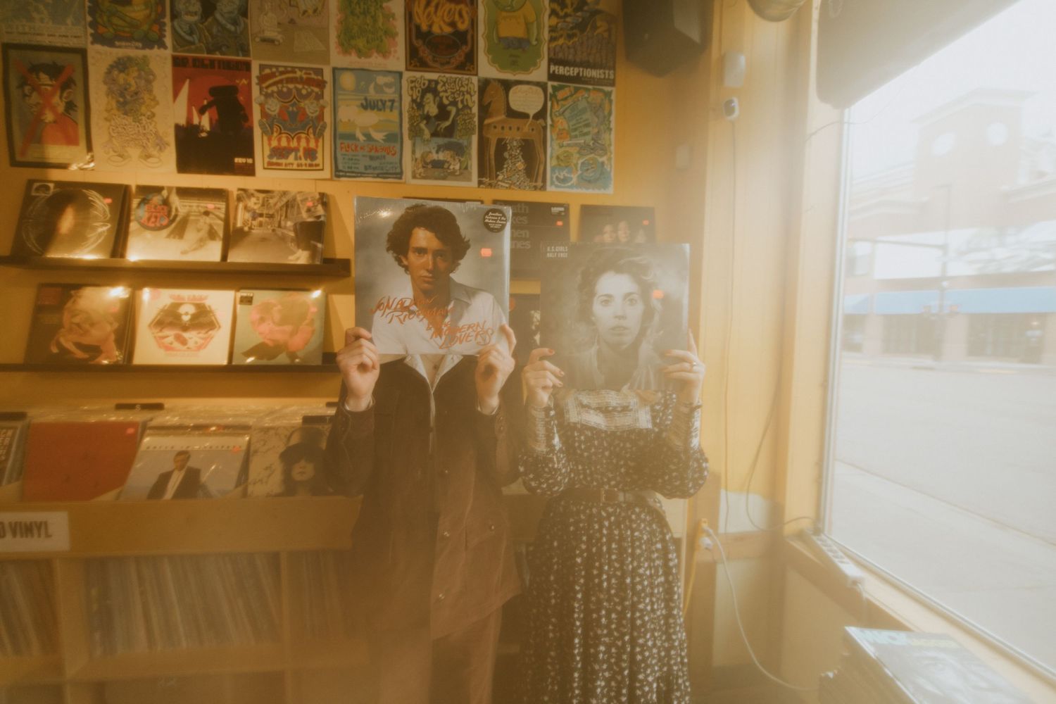 Vintage record store interior with display wall of album covers and sunlit window.