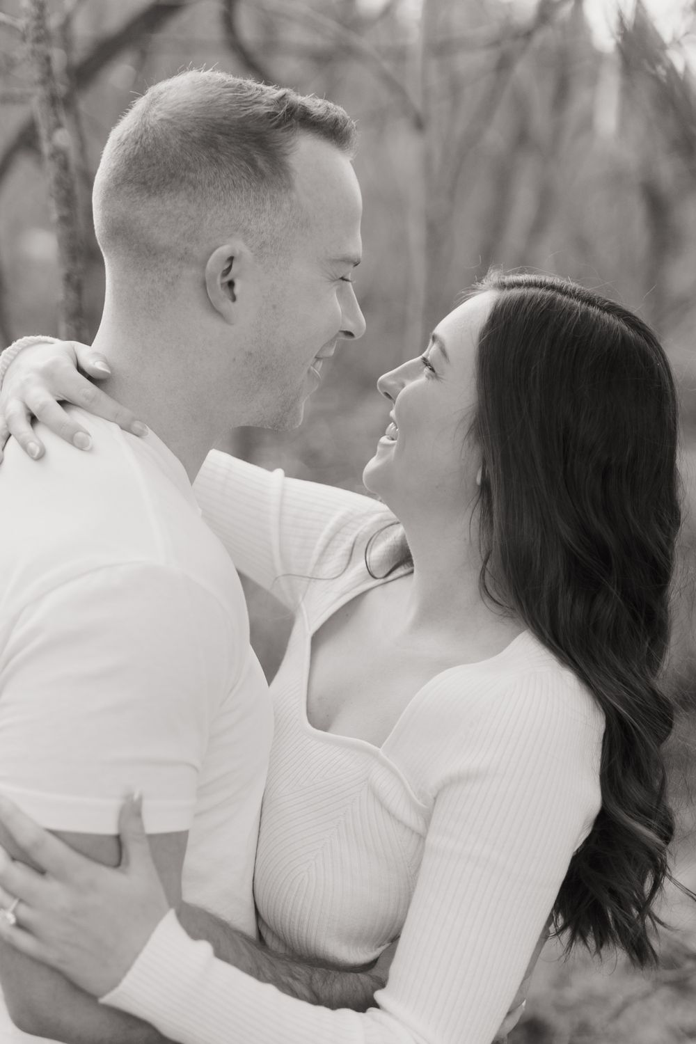 Black and white portrait of a happy couple sharing an intimate moment outdoors.