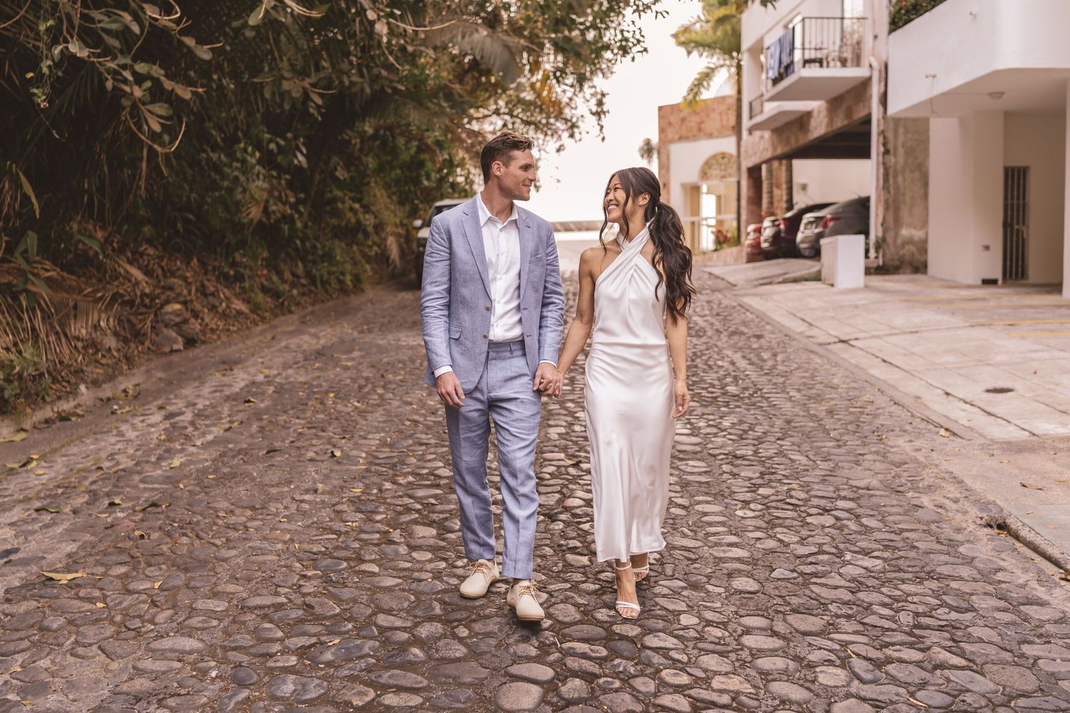 Bride and groom walking down a cobblestone road at Grand Miramar Resort in Puerto Vallarta, Jalisco, Mexico