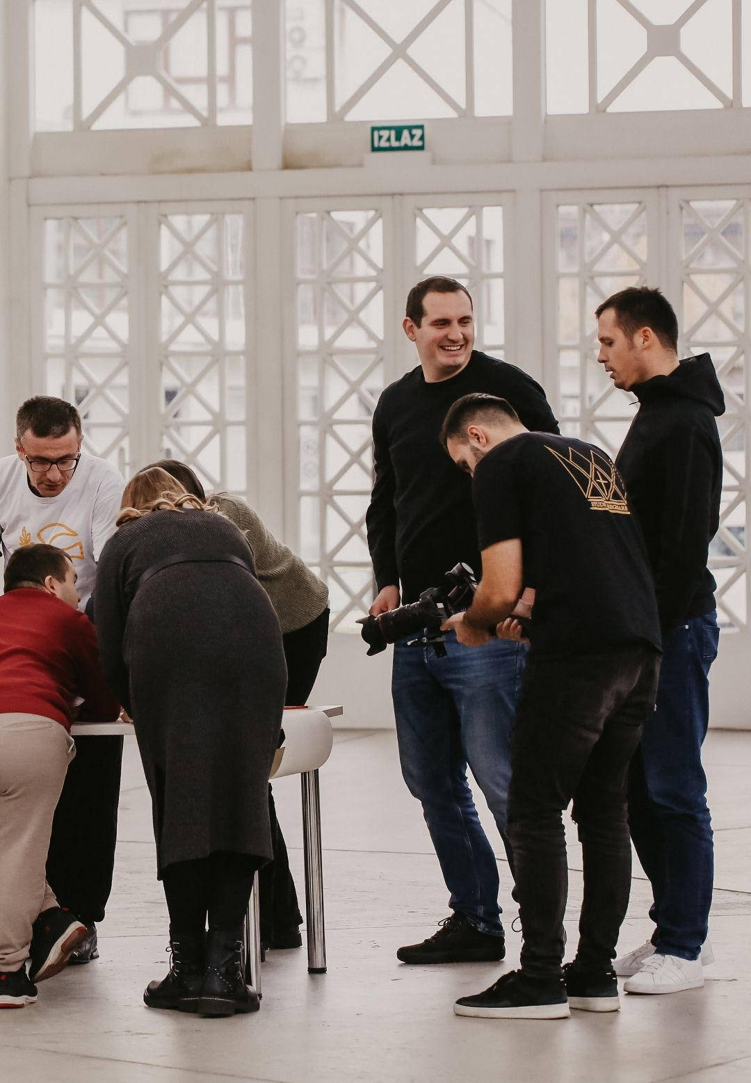 Group of photographers and event staff gathered around a table during a production meeting.