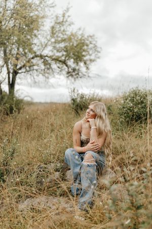 Artistic outdoor portrait in tall grass with moody overcast lighting. Virginia graduation/senior session.