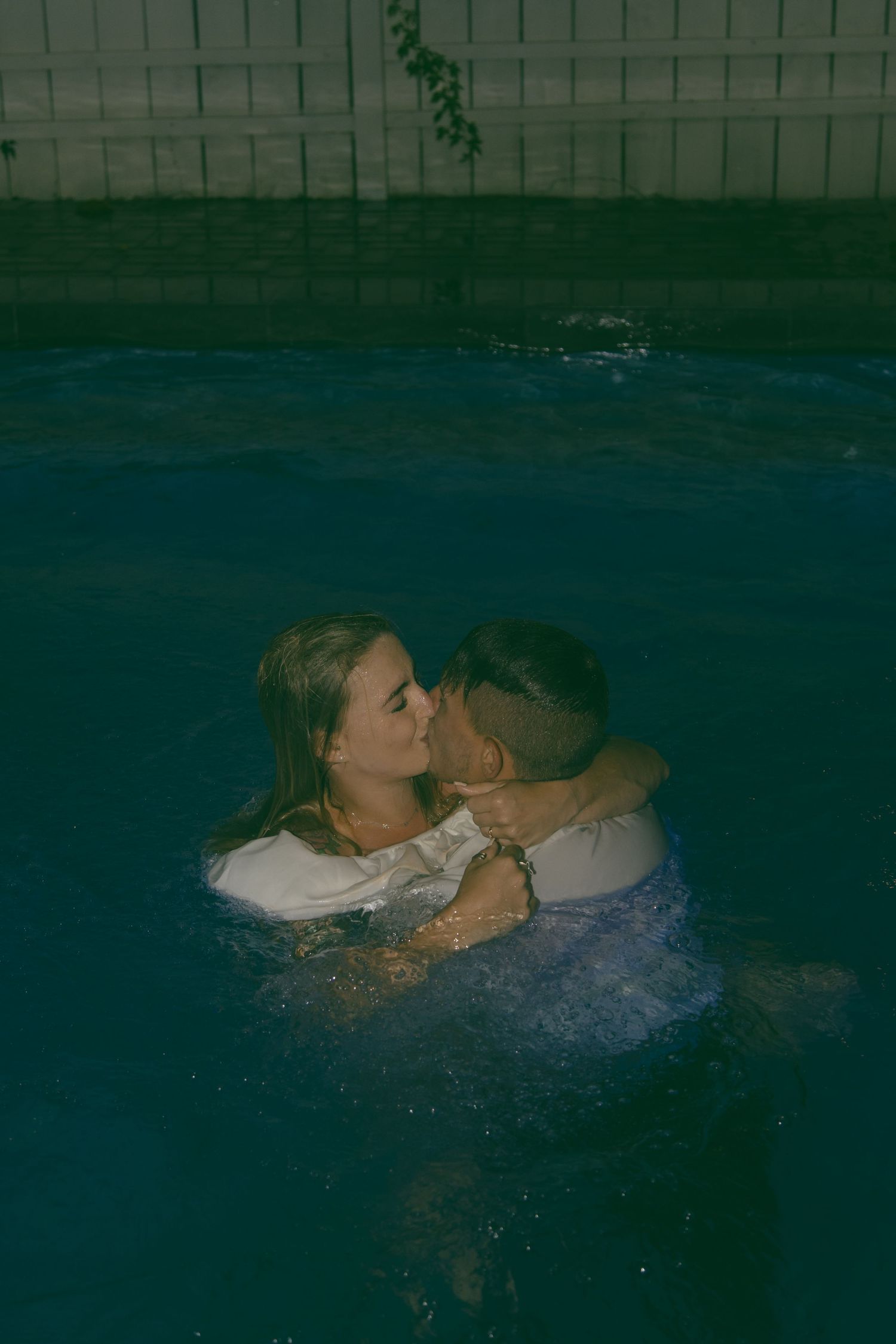 just married eloped couple kissing in pool