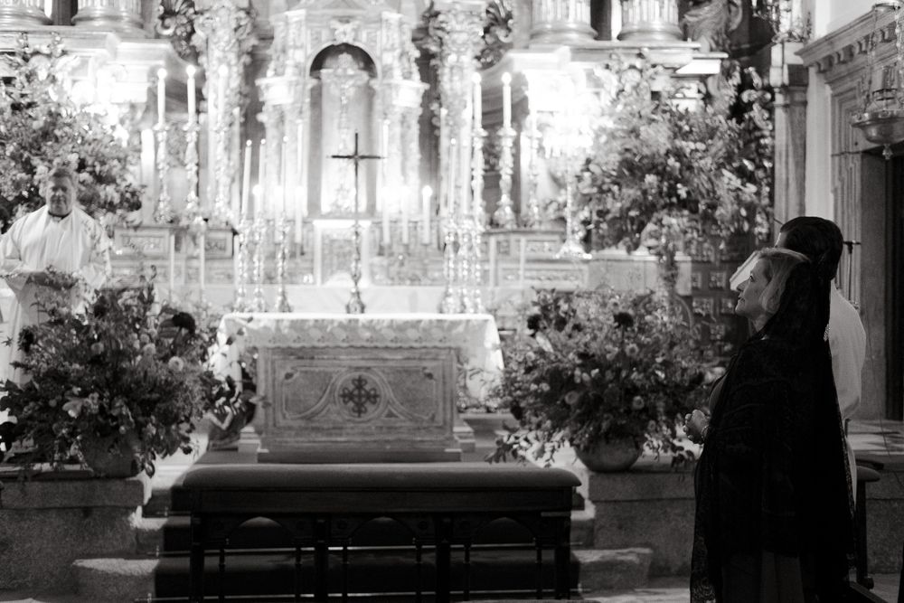 Black and white photo of ornate church altar with floral decorations.