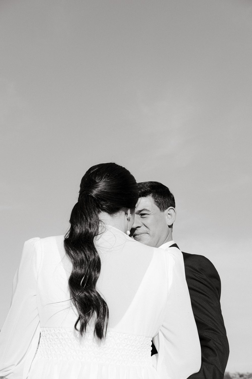 Artistic black and white portrait of newlyweds in minimalist composition.