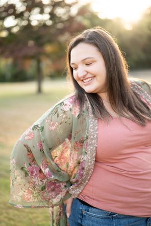 Outdoor portrait featuring a floral kimono and pink top against a sunset background.
