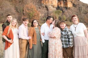 Group portrait of family members posed together against a rocky cliff backdrop.