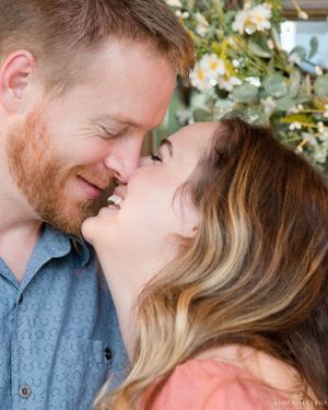 Intimate romantic portrait with natural light and floral background.